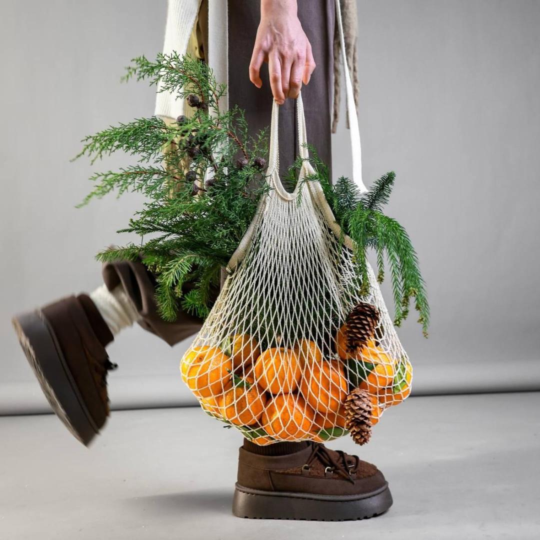 Авоська с мандаринами и ветками хвои