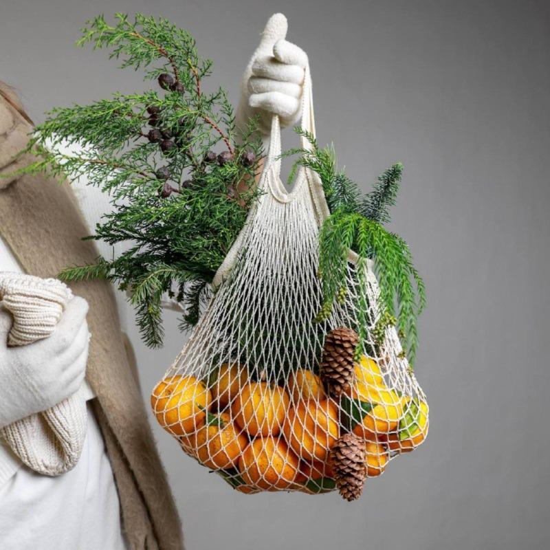 Авоська с мандаринами и ветками хвои